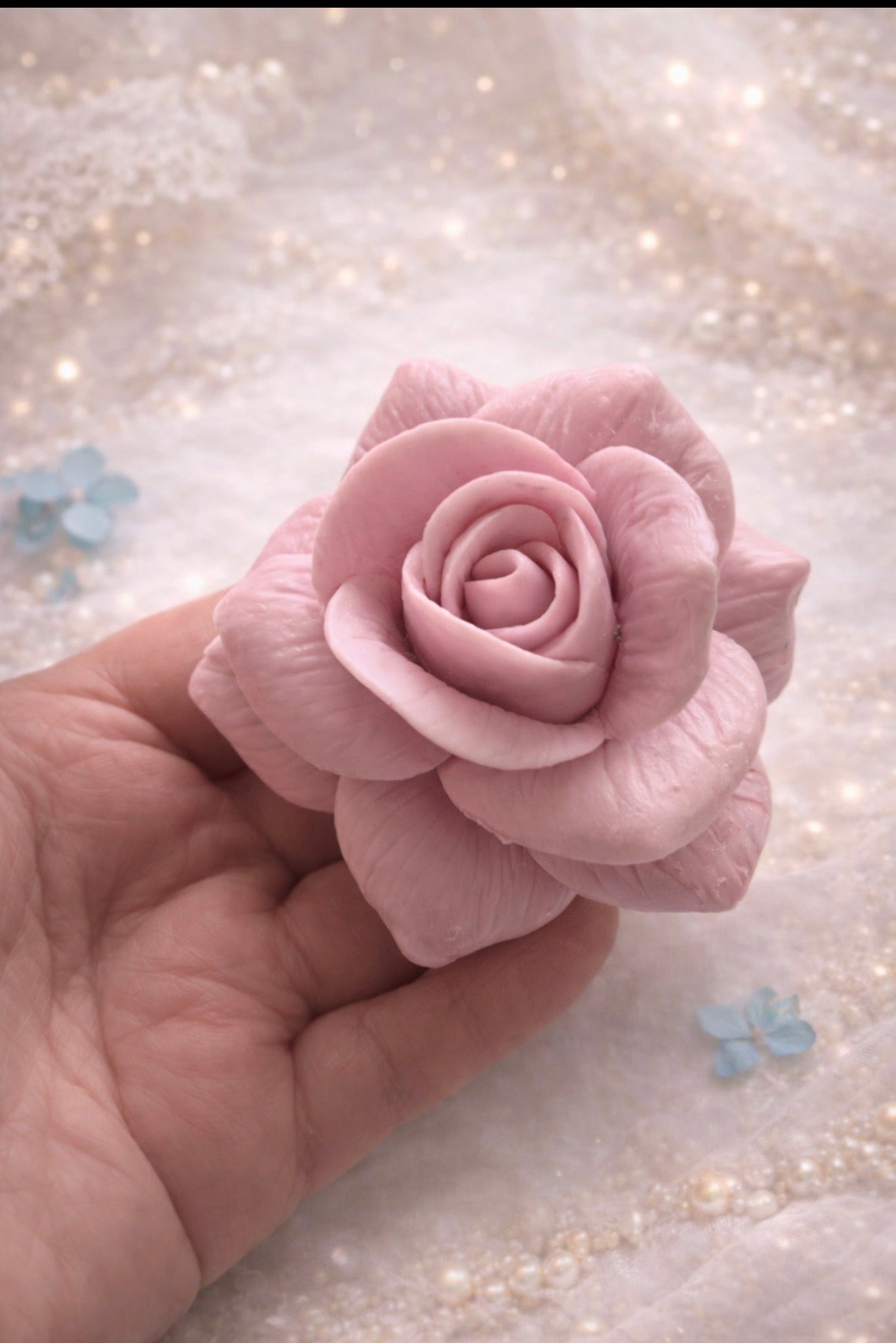 Handmade pink rose soap held in hand, delicate floral soap from luxury spa gift box