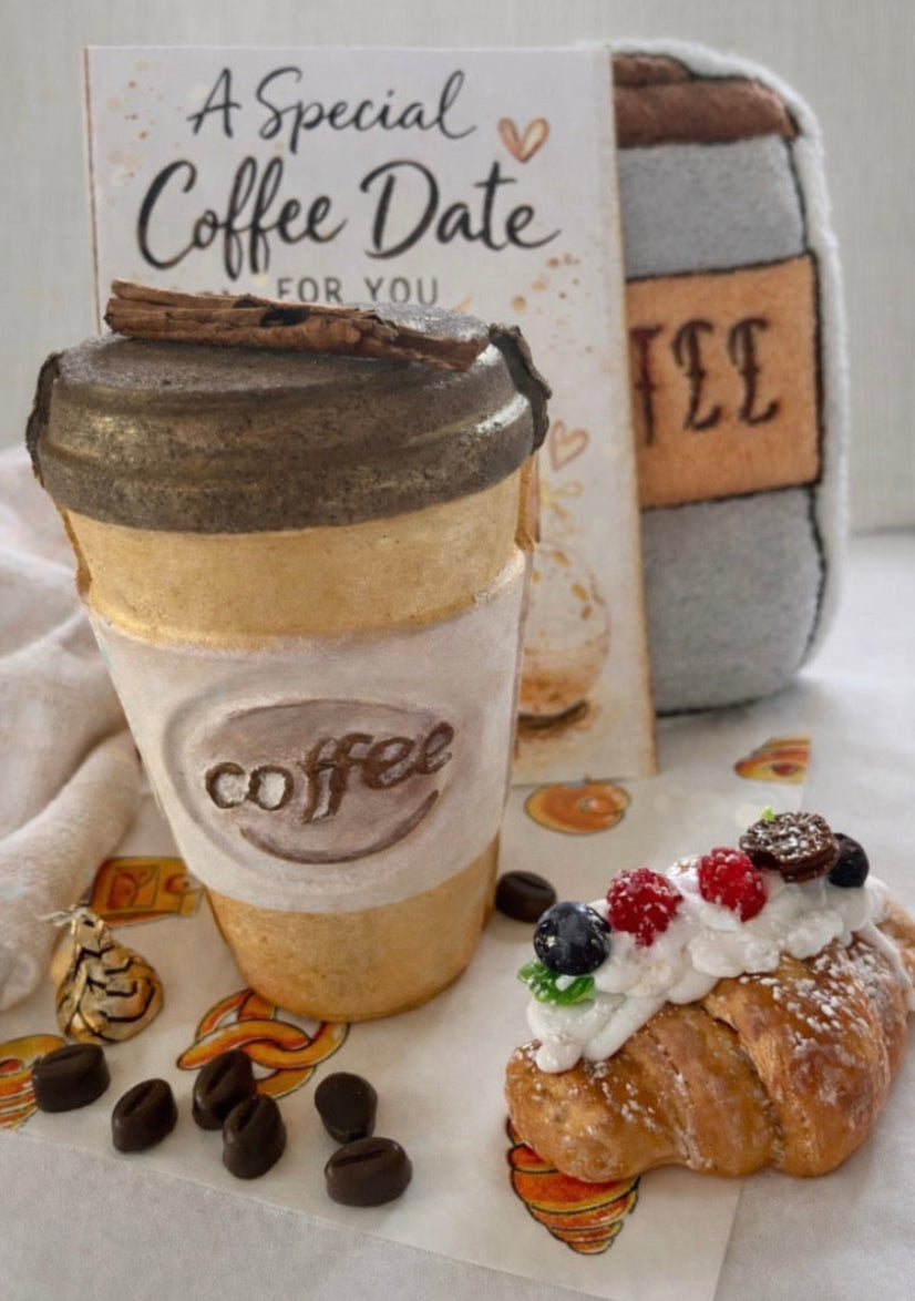 Coffee cup handmade bath bomb with a croissant soap and card on a textured surface