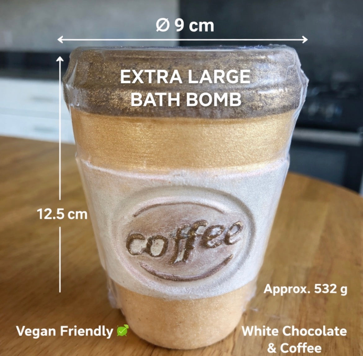 Bath bomb shaped like a coffee cup with measurements and text on a wooden surface.