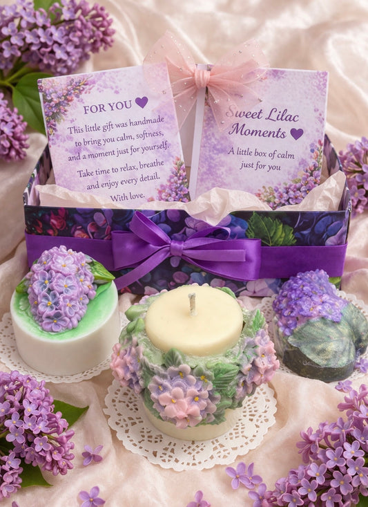 Lilac Spa Gift Box for Her with handmade floral soap, soy candle and bath bomb in a purple gift box with personalised card and satin ribbon, surrounded by fresh lilac flowers.