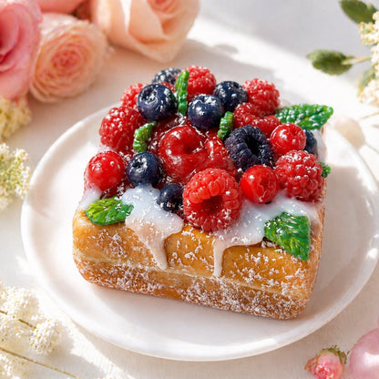 Handmade realistic square double waffle dessert soap with realistic berries and green leaves with a cream top, styled on a white plate.