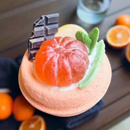 Close up of handmade bath bomb designed like a dessert with mandarin  and chocolate decoration